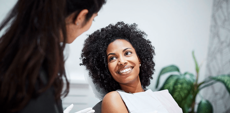 Woman Smiling and Speaking with Dentist